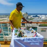 A waiter with an alcohol trolley on the deck of a cruise ship.