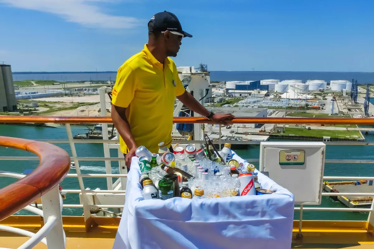 A waiter with an alcohol trolley on the deck of a cruise ship.