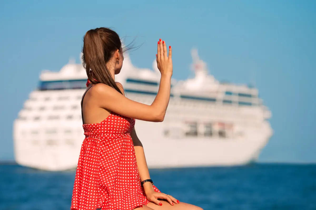 girl waving at a cruise ship
