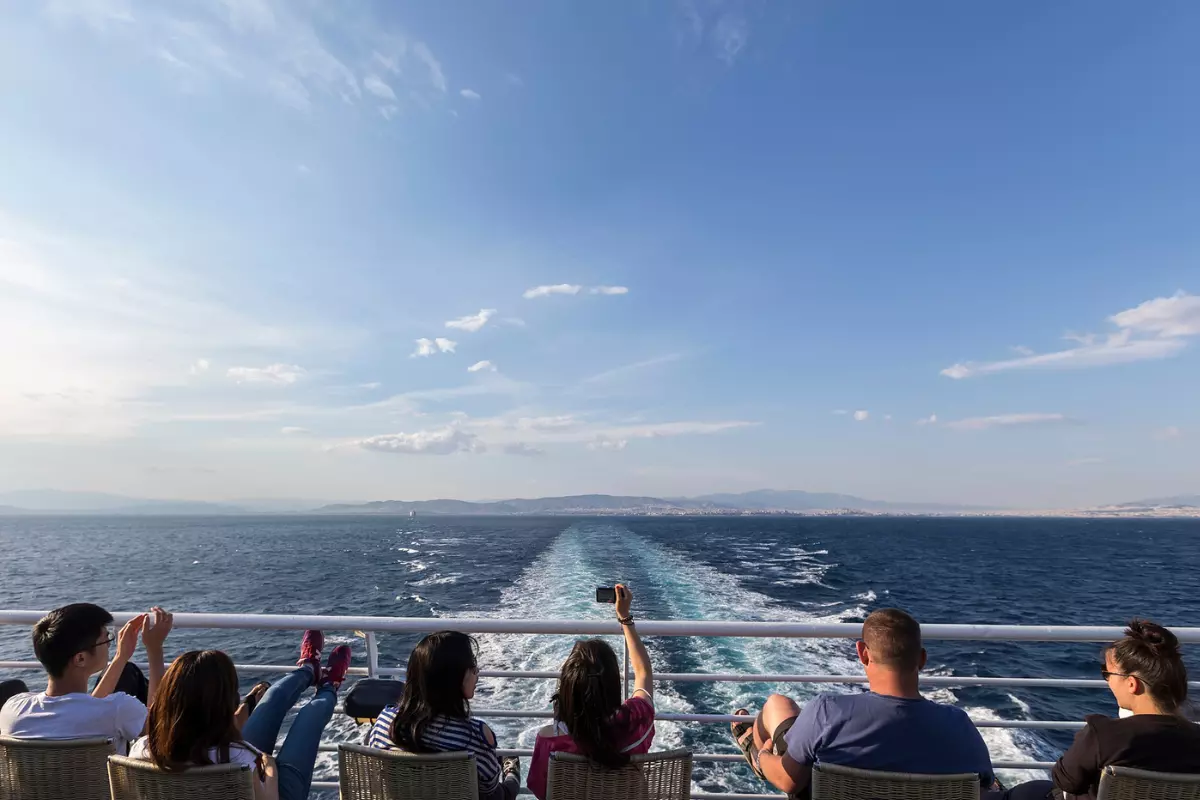Tourists sitting with their mobile phones on a cruise ship.